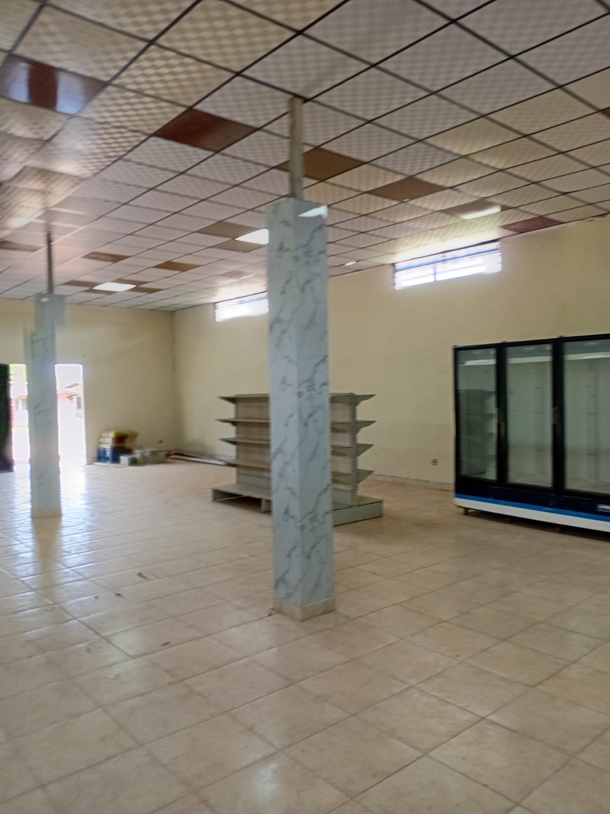 Vista del área de ventas con estantería y refrigerador